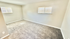 Bright and spacious carpeted room featuring large windows, perfect for a cozy bedroom or inviting home office.