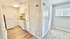 Bright and inviting kitchen area with modern appliances, sleek cabinetry, and elegant wood flooring, complemented by a cozy carpeted adjacent room with ample natural light.