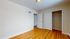 Bright and inviting room with polished wood flooring, a built-in closet, and classic white doors.