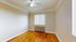 Bright and inviting room featuring polished hardwood floors, a ceiling fan, and natural light from a window with vertical blinds.