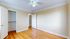 Bright bedroom with elegant hardwood floors and ample closet space, featuring a modern ceiling fan and soft neutral walls.
