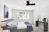 Bright and modern bedroom with stylish decor and large window, featuring a cozy bed and sleek furnishings.