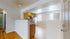 Inviting kitchen with warm wood cabinets, white appliances, and ample natural light, perfect for cozy culinary creations.
