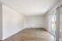 Bright and spacious living area with elegant wooden flooring and large sliding glass door leading to a balcony.