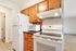 Bright and functional kitchen with wooden cabinets, modern appliances, and stylish flooring.