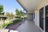 Inviting outdoor patio with elegant railing overlooking a lush green park setting, perfect for relaxation and outdoor enjoyment.