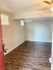 Inviting open room with chic wood flooring, neutral walls, and ample natural light filtering through stylish windows.