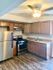 Modern kitchen with sleek wooden cabinets, stainless steel appliances, and elegant lighting.