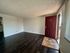 Inviting apartment interior featuring rich dark wood flooring and an elegant maroon door, perfect for a welcoming entrance.