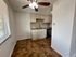 Bright kitchen with elegant cabinetry, granite countertops, and modern tile flooring, featuring abundant natural light from large windows.