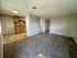Inviting op en-concept living space with plush carpet, adjoining a cozy kitchen with wood cabinets and stylish tile flooring.