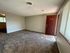 Inviting living space with plush carpeting, neutral walls, and natural light streaming through large windows, enhancing the cozy ambiance.