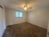Inviting bedroom with cozy carpet, a ceiling fan, and ample natural light from a large window.