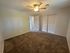 Inviting bedroom with plush carpet, ceiling fan, and ample closet space in modern apartment.