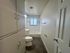 Bright and spacious bathroom featuring a sleek white design, modern fixtures, and ample storage space.