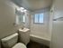 Bright bathroom with modern fixtures, featuring a bathtub, vanity, and a large mirror under natural light.