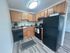 Modern kitchen with sleek black appliances, abundant wooden cabinetry, and elegant countertops, offering a functional and stylish cooking area.