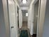 Inviting hallway leading to multiple rooms with modern wood flooring and bright white doors, ideal for a cozy apartment layout.