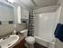 Elegant bathroom featuring a modern sink, stylish countertop, and chic shower with patterned curtain.