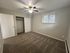 Bright bedroom with soft carpet flooring, a ceiling fan, and ample closet space, ideal for relaxation and comfort.