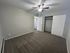 Spacious bedroom with plush carpeting, large closet, and ceiling fan creating a cozy and inviting space.