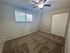 Bright, cozy room with freshly cleaned carpet, large window, and ceiling fan, perfect for a bedroom or home office.