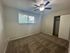 Bright bedroom with fresh carpet, ceiling fan, and large window providing ample natural light and an inviting atmosphere.