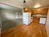 Inviting kitchen and living area with warm wood cabinets, modern appliances, and cozy carpeted space perfect for relaxation.