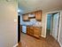 Charming kitchen with warm wood cabinets, modern appliances, and tiled flooring, offering a cozy culinary space.