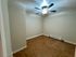 Cozy room with sleek tiled flooring, neutral walls, and a modern ceiling fan, perfect for versatile living.