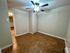 Inviting room with beige walls, modern ceiling fan, and chic tiled flooring, perfect for customization.