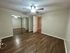 Spacious bedroom with elegant wood flooring, mirrored closet doors, and modern ceiling fan for a cozy atmosphere.