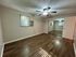 Spacious bedroom featuring sleek hardwood floors, mirrored closet doors, and a ceiling fan for enhanced comfort.