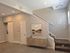 Elegant modern entryway with neutral decor, featuring a stylish staircase, wall art, and a sleek console table in a cozy, well-lit space.