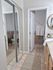 Inviting bathroom featuring elegant tile flooring, a large mirror, and modern decor with soft neutral tones.