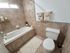 Cozy bathroom featuring warm tile design, a relaxing bathtub, and soft lighting for an inviting atmosphere.