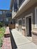 Charming apartment exterior with a private patio, inviting entrance, and lush greenery.