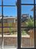 Charming garden view from apartment window showcasing a sunny outdoor area with wooden fencing and lush greenery.