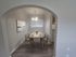 Charming dining area with elegant lighting, modern decor, and seating for four under a cozy arched entryway.