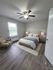 Elegant bedroom with modern decor featuring a comfortable bed, stylish lighting, and natural light from a large window.