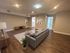 Modern open living space featuring a cozy gray sectional sofa, stylish wood flooring, and elegant wall art accents.