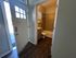 Inviting entryway leading to a modern bathroom with elegant tilework and a warm, welcoming ambiance.