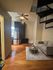 Cozy modern apartment interior featuring a stylish spiral staircase, sleek kitchen with stainless steel appliances, and a comfortable living area with elegant wooden flooring.