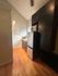 Charming kitchen nook featuring sleek dark cabinetry, modern appliances, and warm wood flooring for a cozy feel.