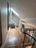 Bright and inviting loft-style living area with natural light, cozy sitting spot, and modern staircase design.