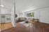 Inviting living space with modern decor featuring a cozy sofa, wooden furniture, and an adjacent open kitchen with sleek appliances.