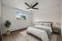 Bright and modern bedroom with a cozy bed, stylish ceiling fan, and elegant decor, featuring natural light from a large window.