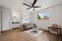 Inviting living space featuring a cozy gray sofa, modern ceiling fan, and bright window view, complemented by sleek wood flooring and a compact dining area.