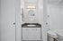 Contemporary bathroom featuring a sleek oval mirror, elegant vanity, and cozy bathtub setting.