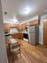 Inviting kitchen with wooden cabinets, modern appliances, and a cozy dining area, perfect for intimate meals.